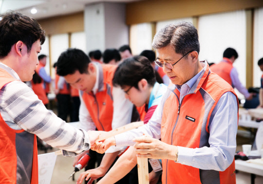 서승화 한국타이어 부회장(오른쪽)이 23일 서울 역삼동 본사에서 봉사활동에 참여해 어린이들을 위한 친환경 가구를 직접 제작하고 있다.   한국타이어 제공